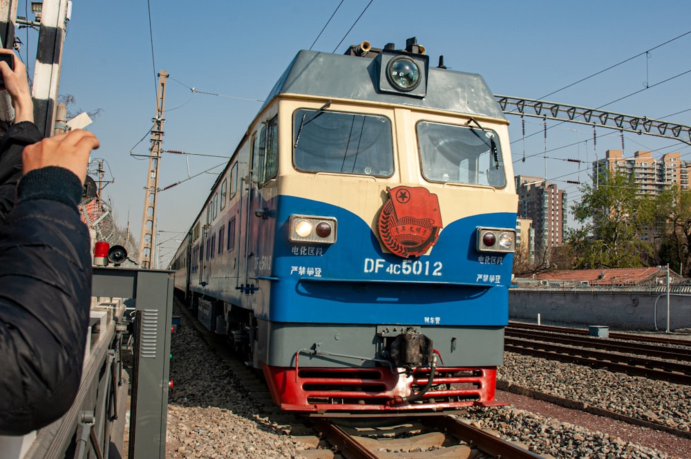 a person taking a picture of a train on the tracks