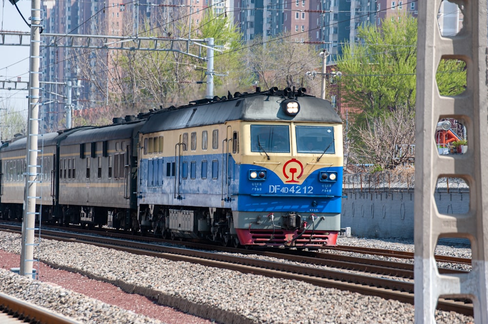 a blue and yellow train traveling down train tracks