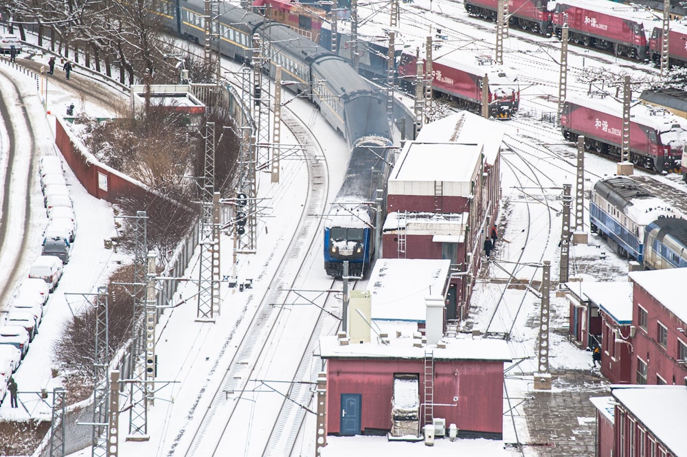 a train traveling down train tracks next to snow covered ground