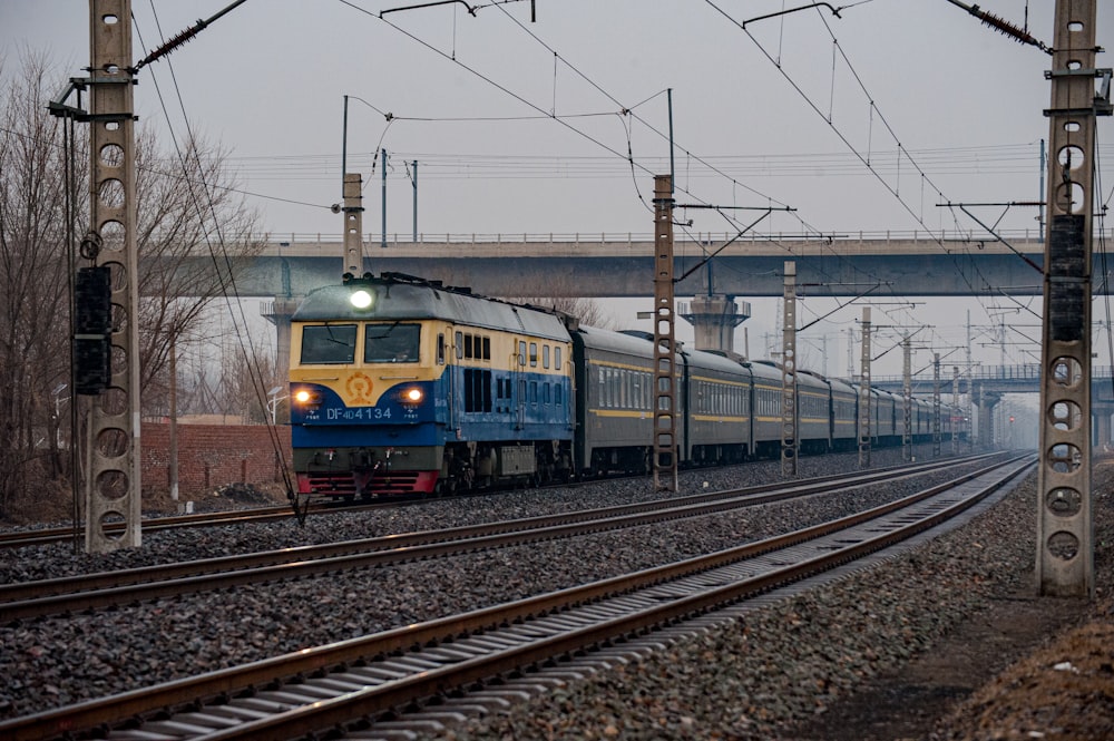 a blue and yellow train traveling down train tracks