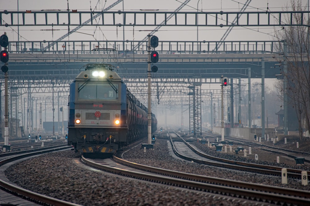 a train traveling down train tracks under a bridge