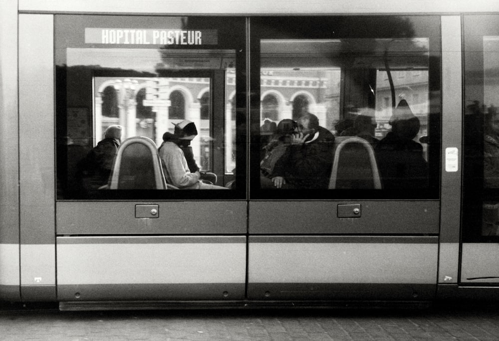 a black and white photo of people on a bus