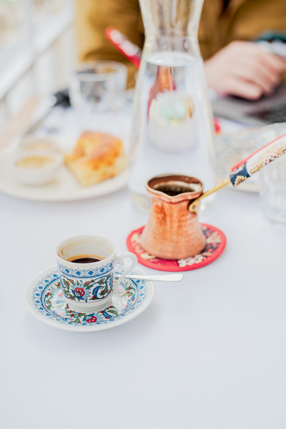 a person sitting at a table with a cup of coffee