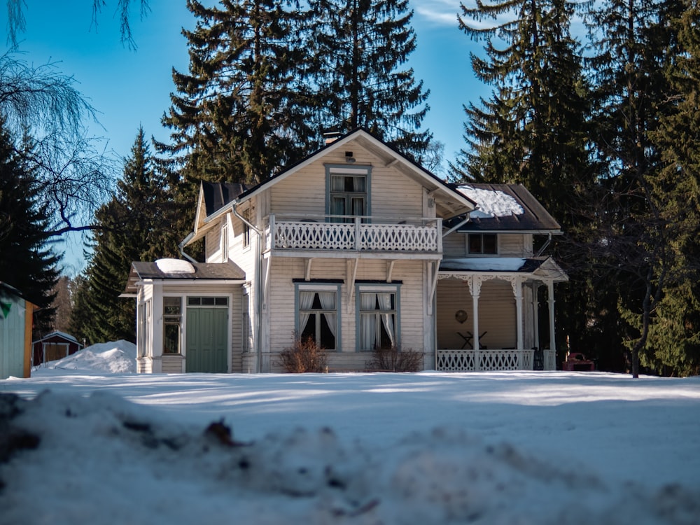 a white house in the middle of a snow covered field