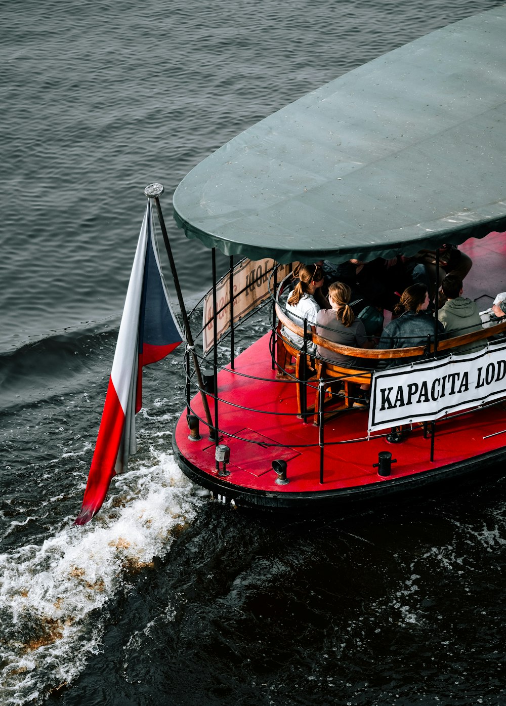 a red and white boat with people on it