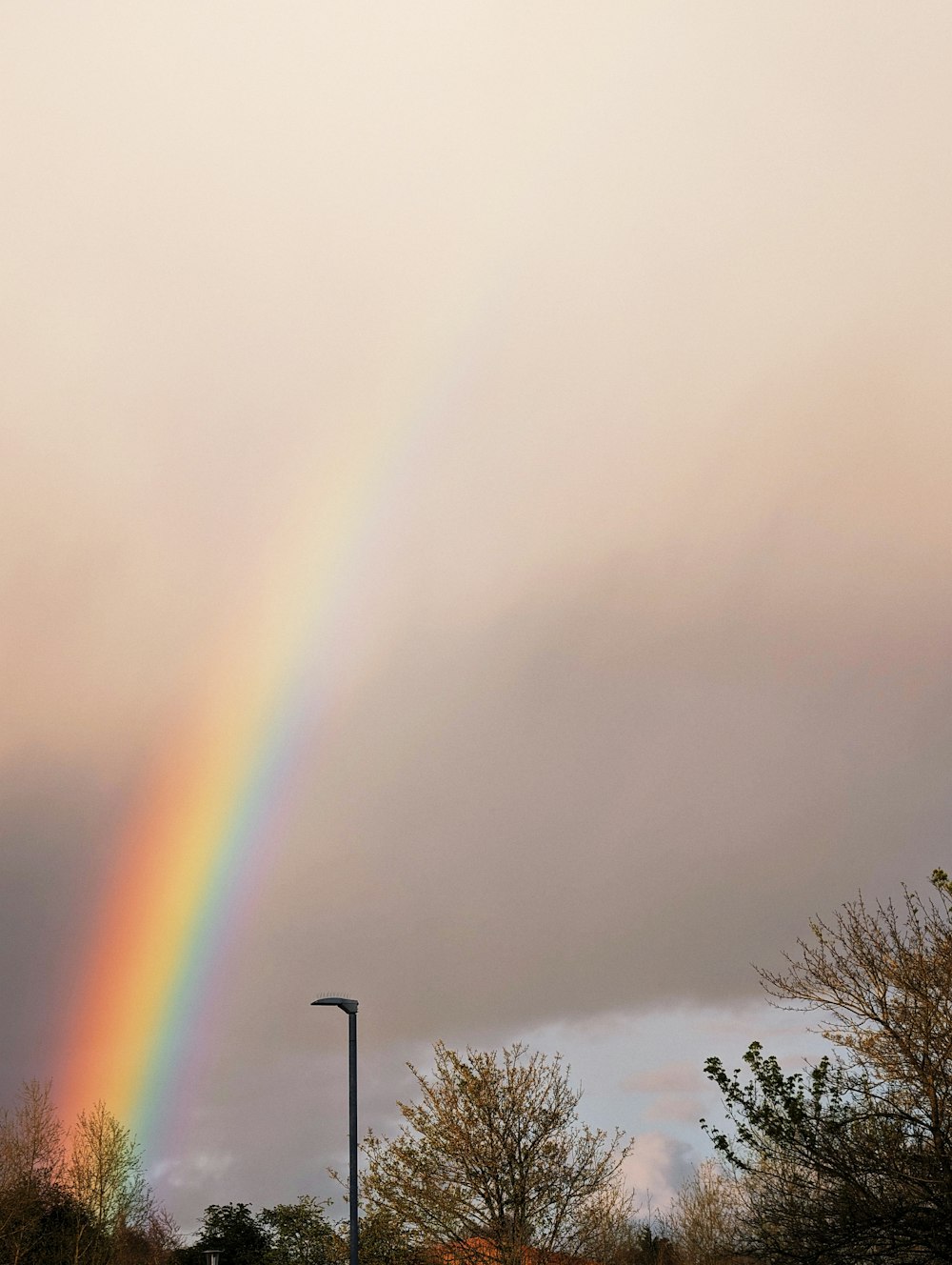 a rainbow appears in the sky over a parking lot