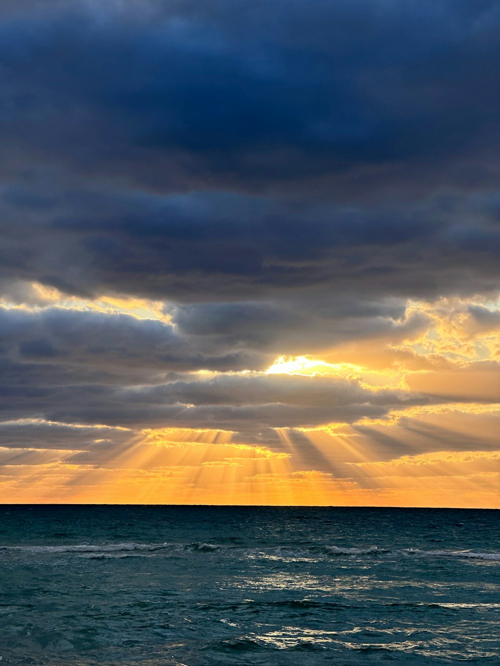 Die Sonne scheint durch die Wolken über dem Ozean