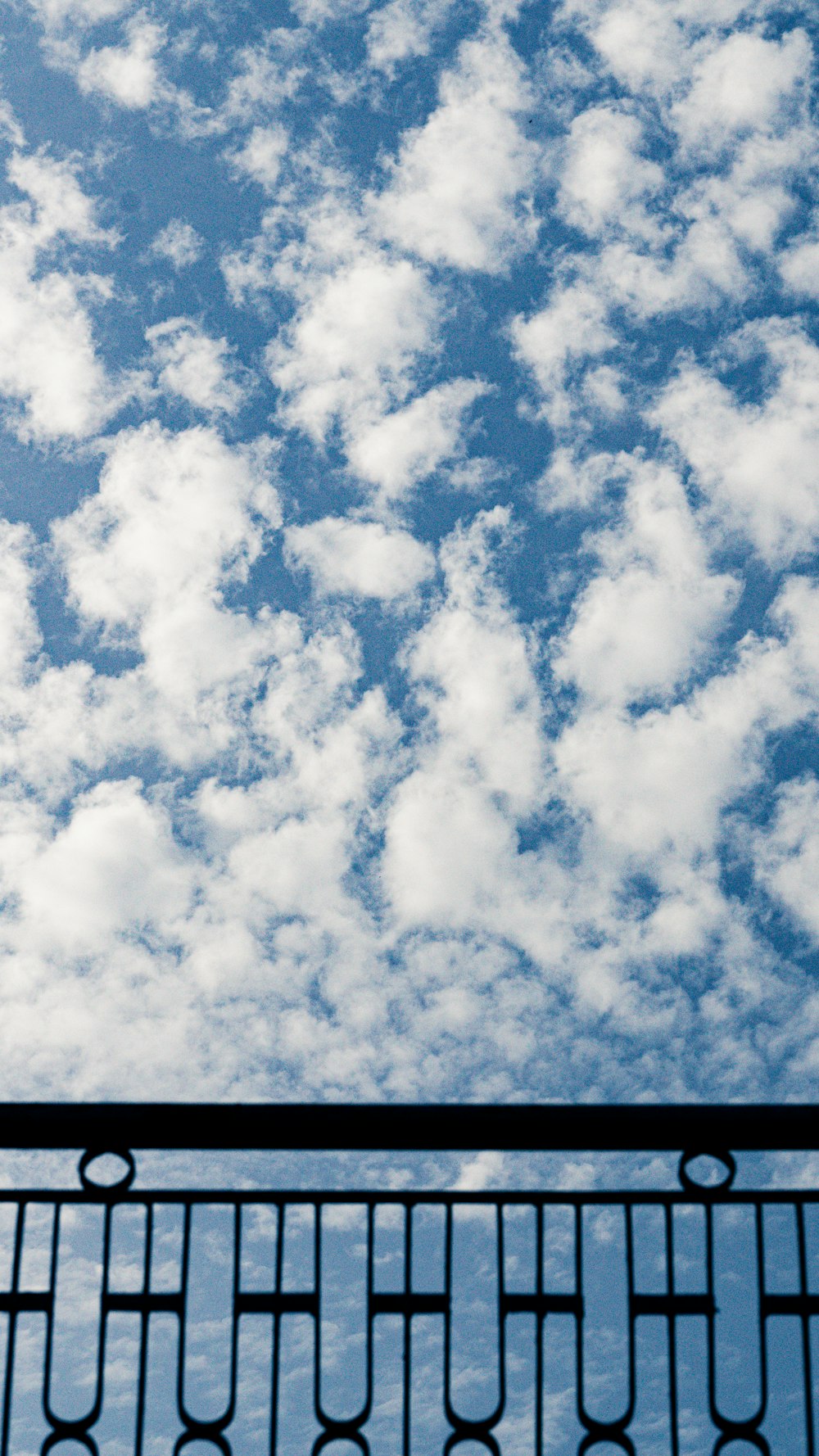 a plane flying in the sky over a fence