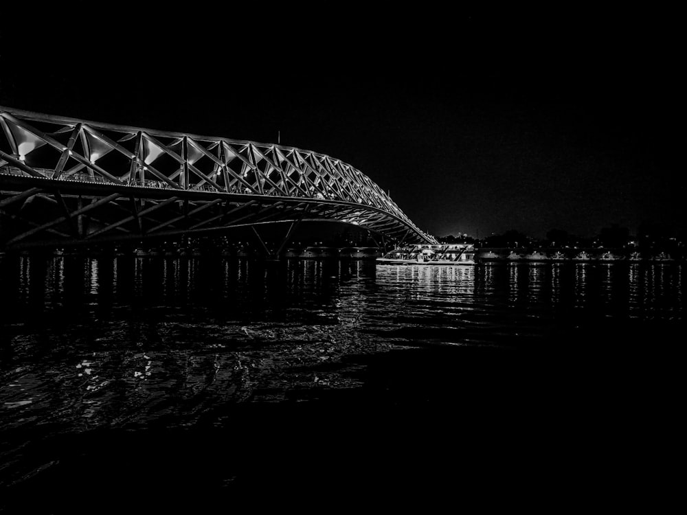 a black and white photo of a bridge over water