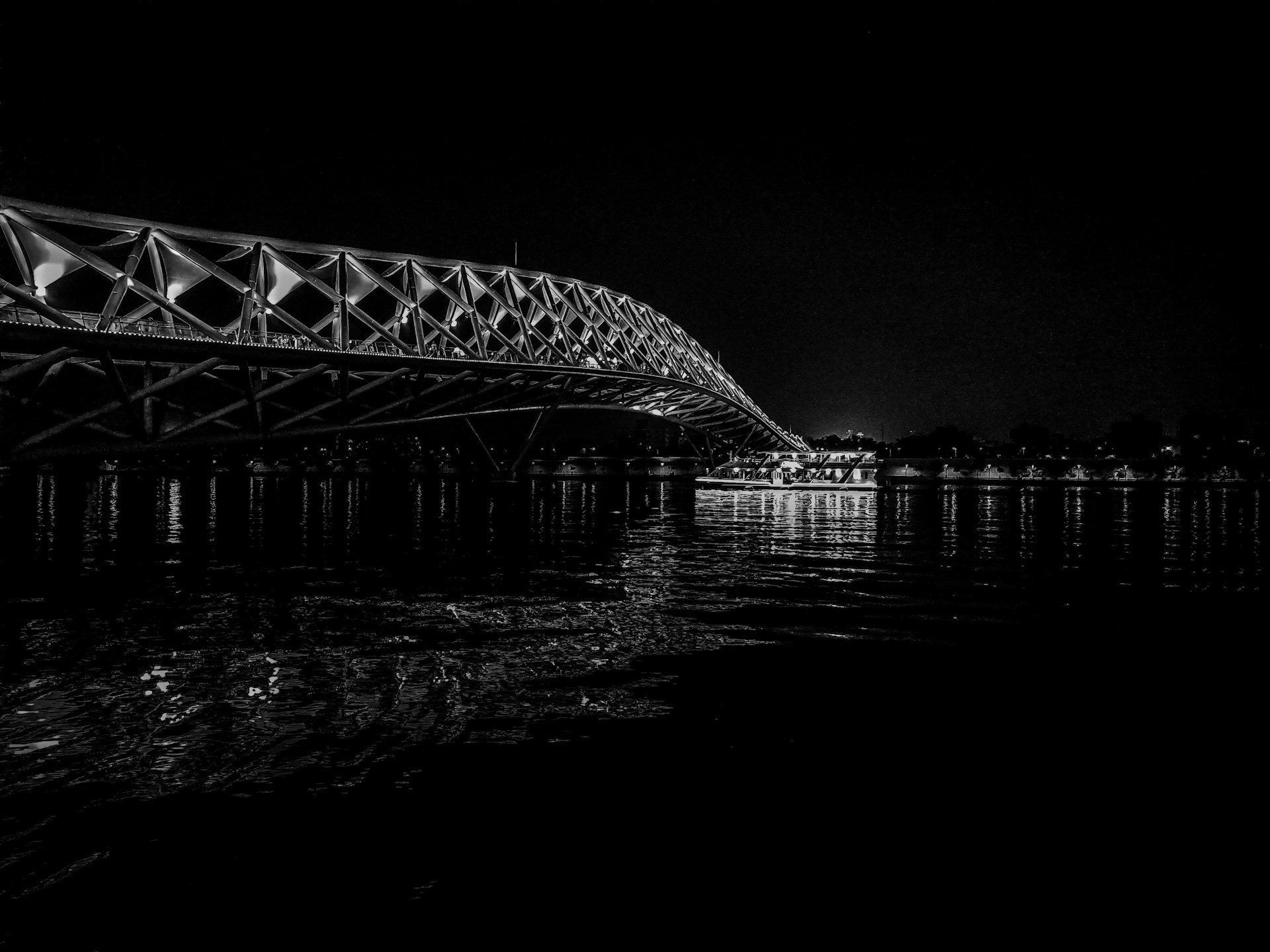 a black and white photo of a bridge over water