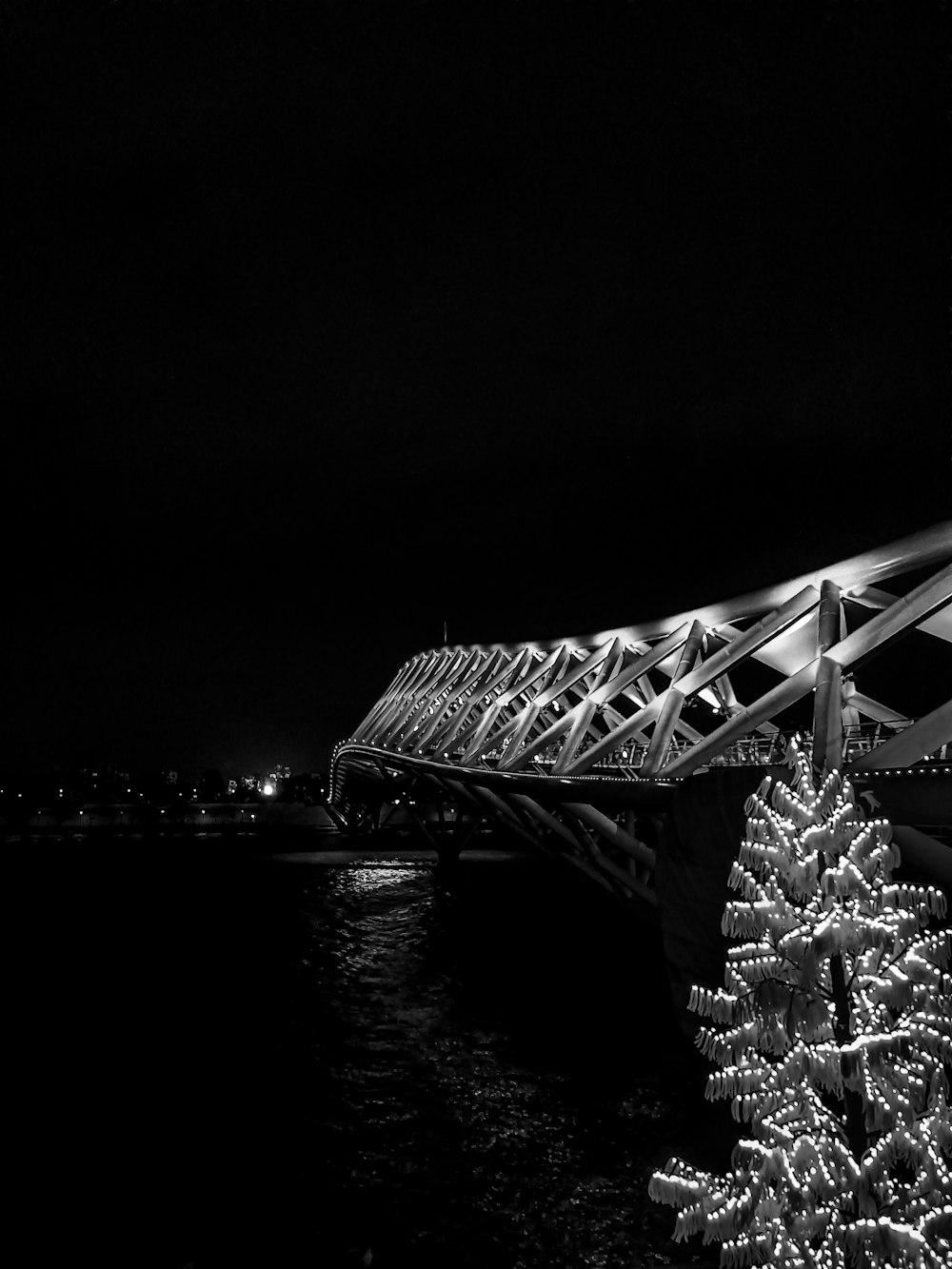 a lit up christmas tree next to a bridge