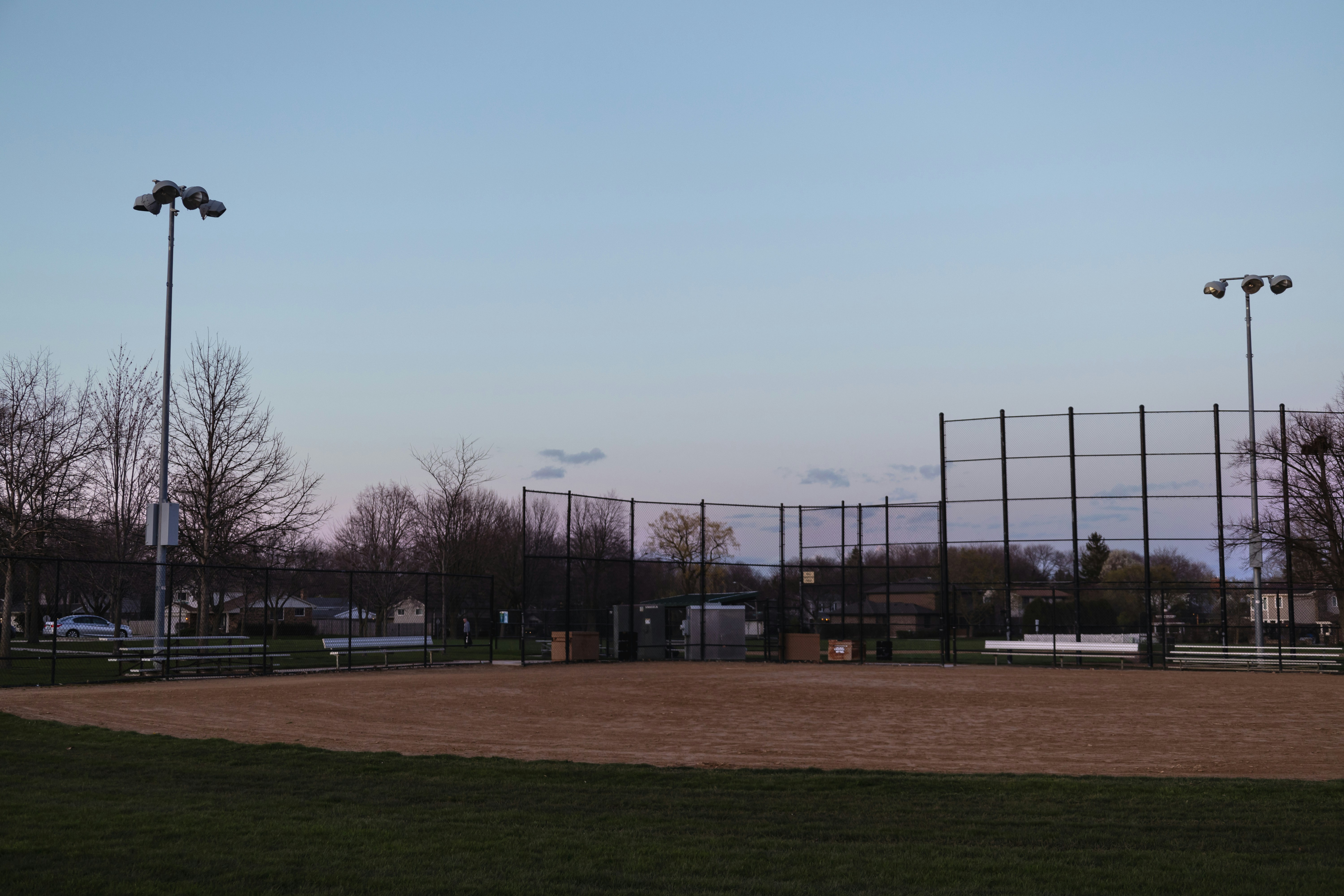 ein Baseballfeld mit Zaun und Lichtern