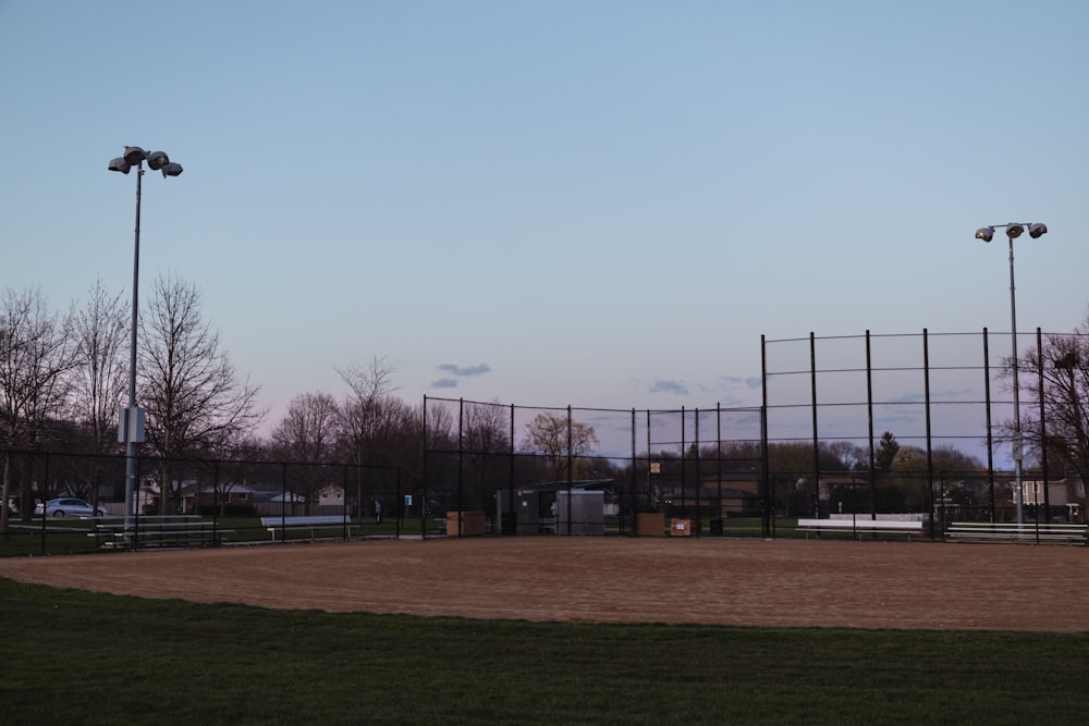 a baseball field with a fence and lights