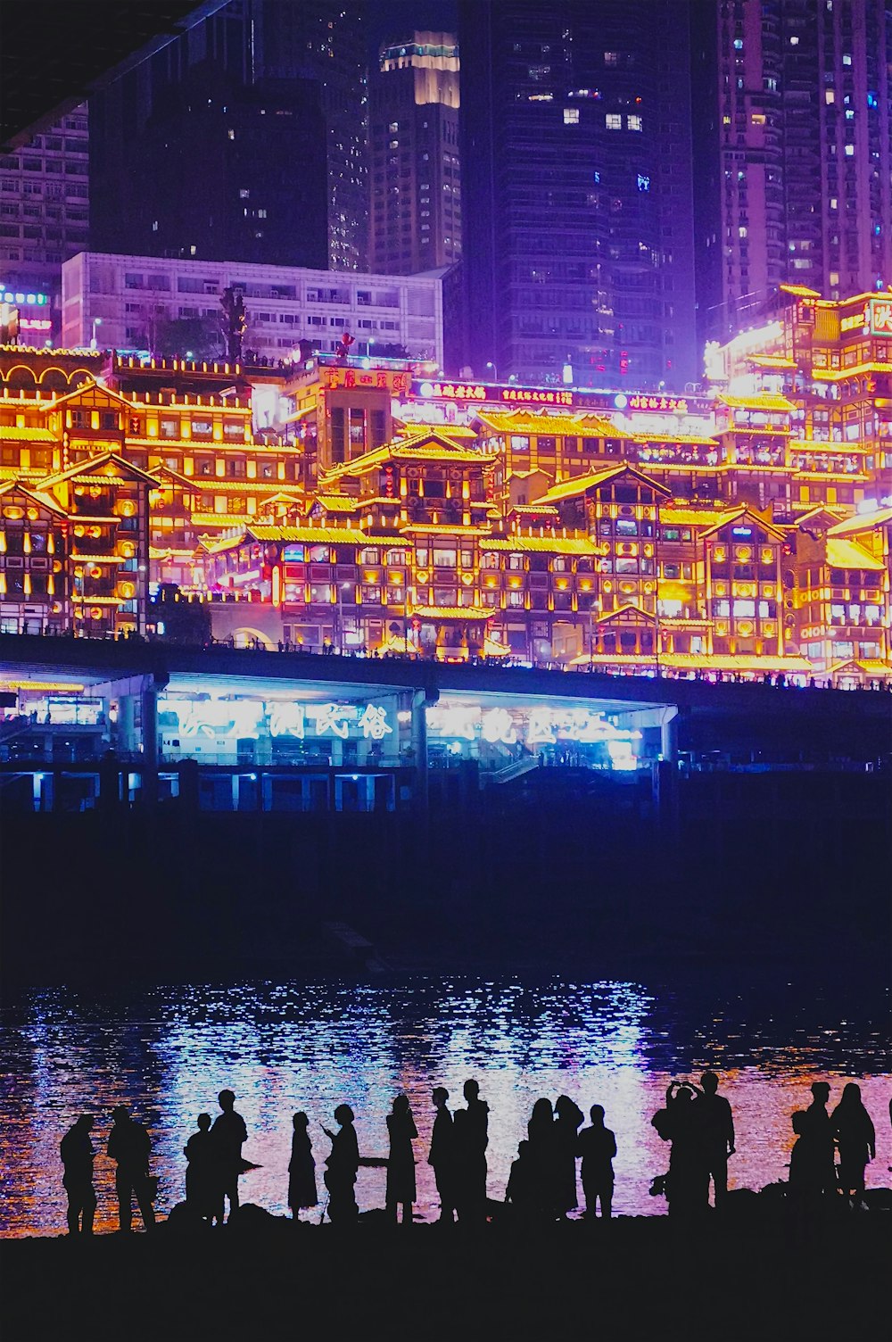 a group of people standing next to a body of water