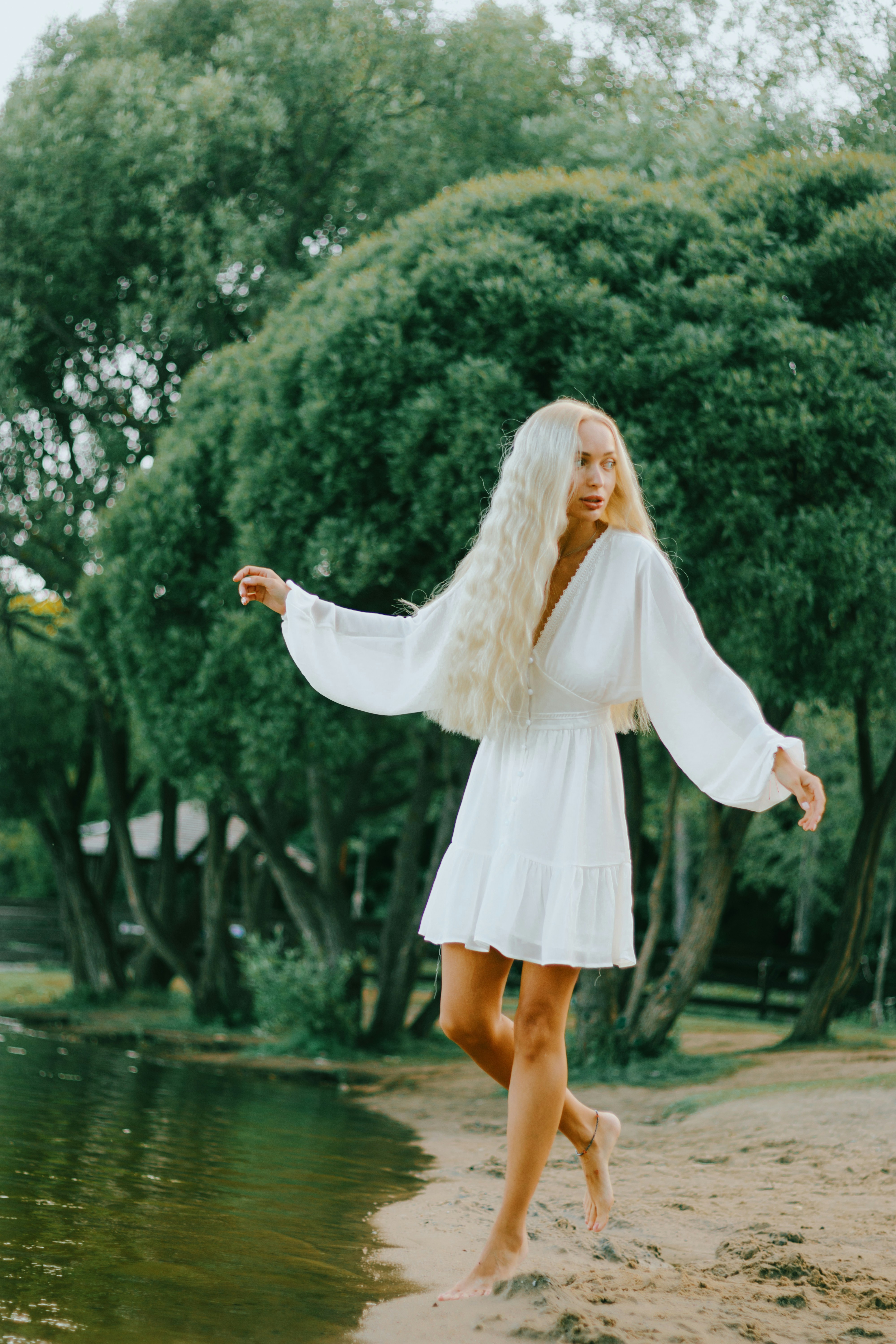 a woman in a white dress standing on a beach