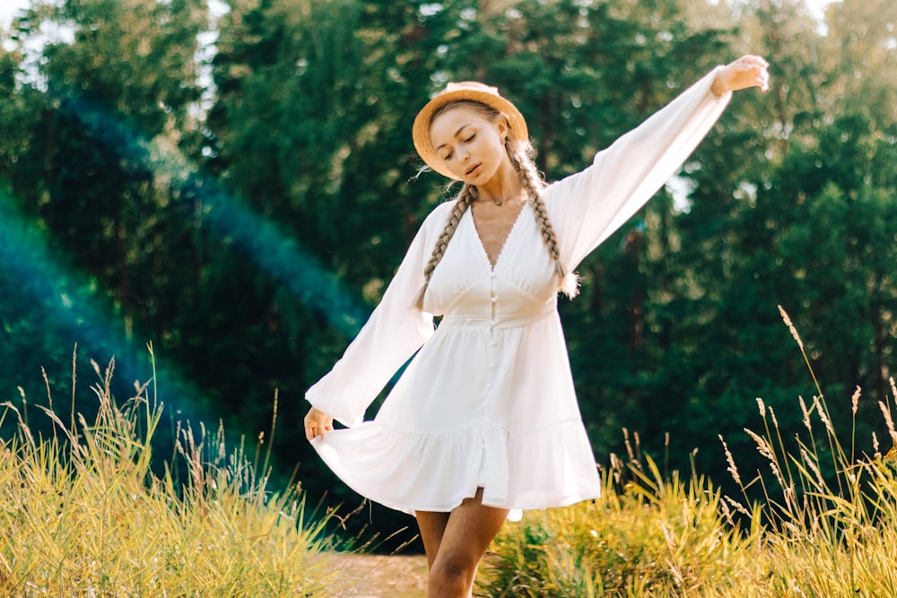 a woman in a white dress and straw hat