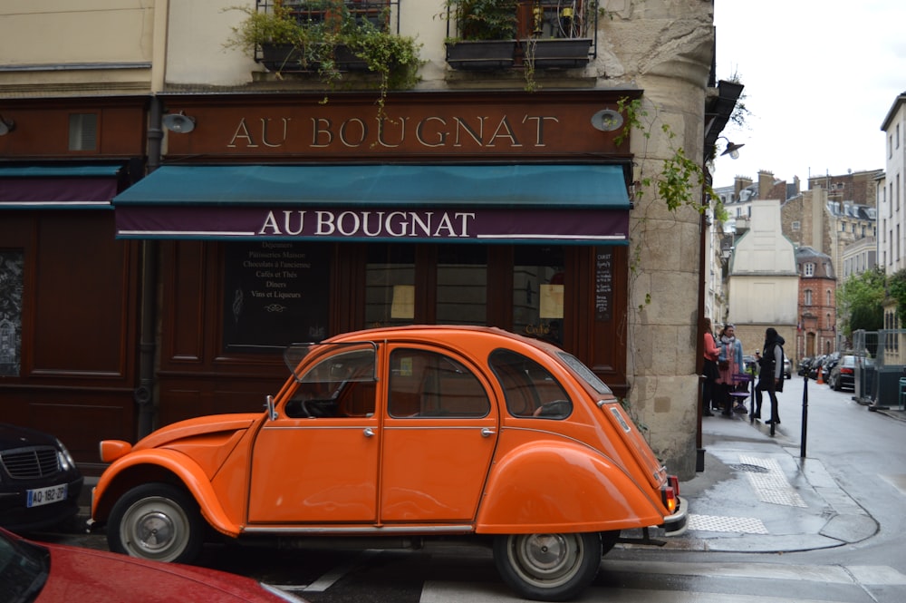 an orange car parked on the side of a street