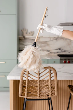 a person in white gloves is cleaning a chair
