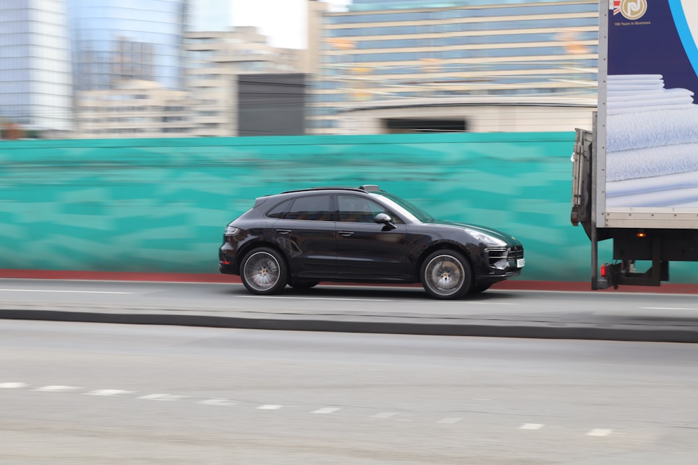 a black porsche cayen is driving down the road