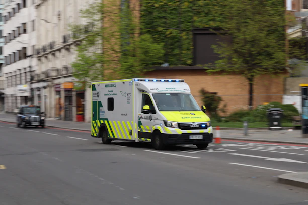 an ambulance driving down a city street next to tall buildings