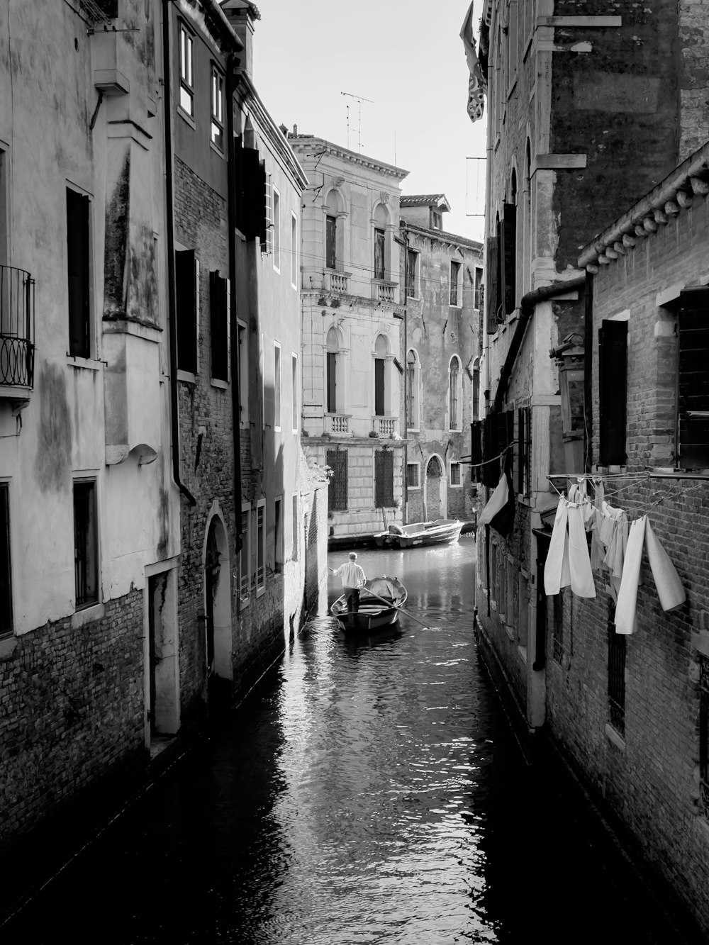 Une photo en noir et blanc d’un canal dans une ville