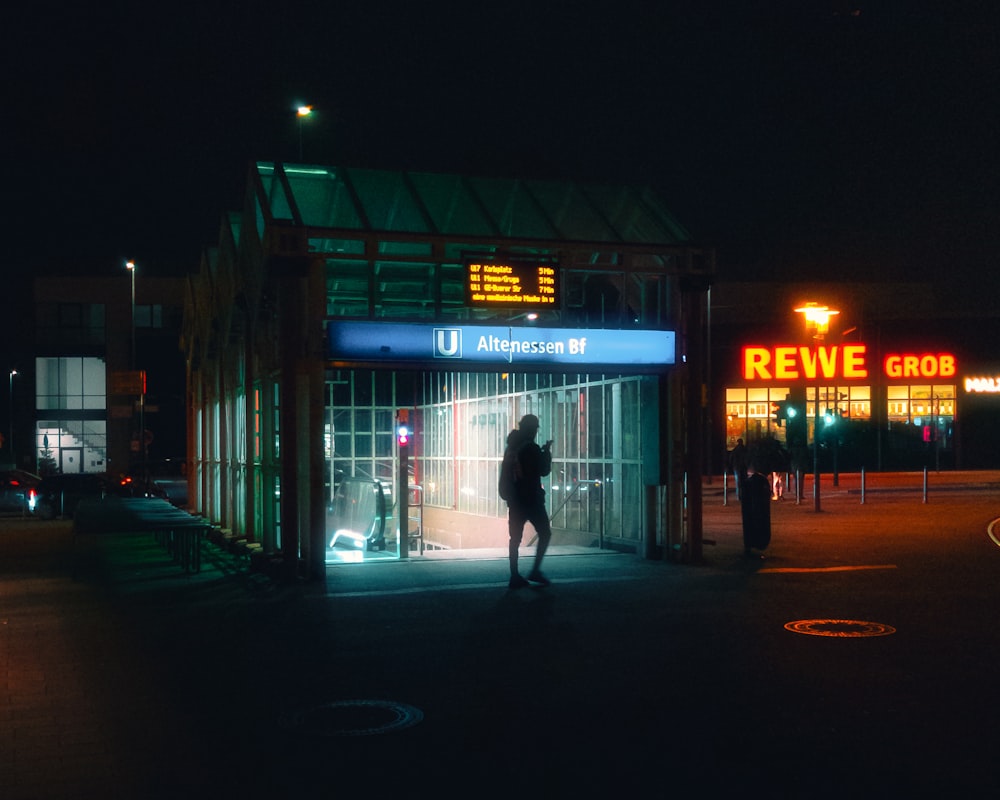 a person standing in front of a store at night