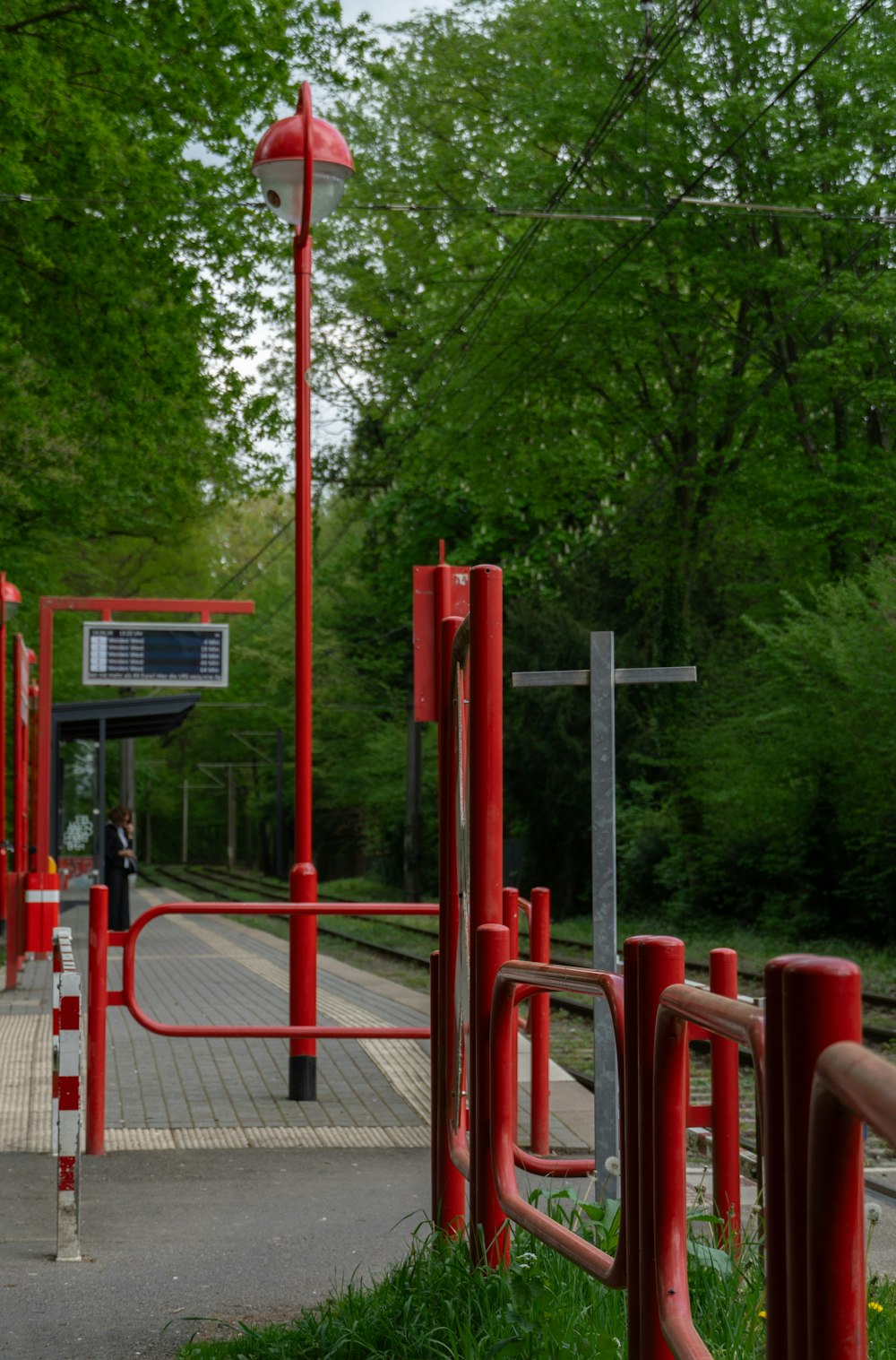 a train station with a red fence and a red light