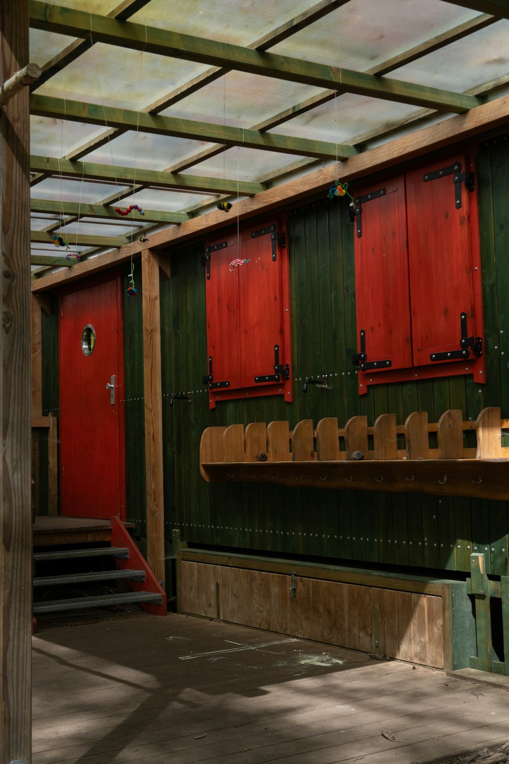 a green and red building with red doors