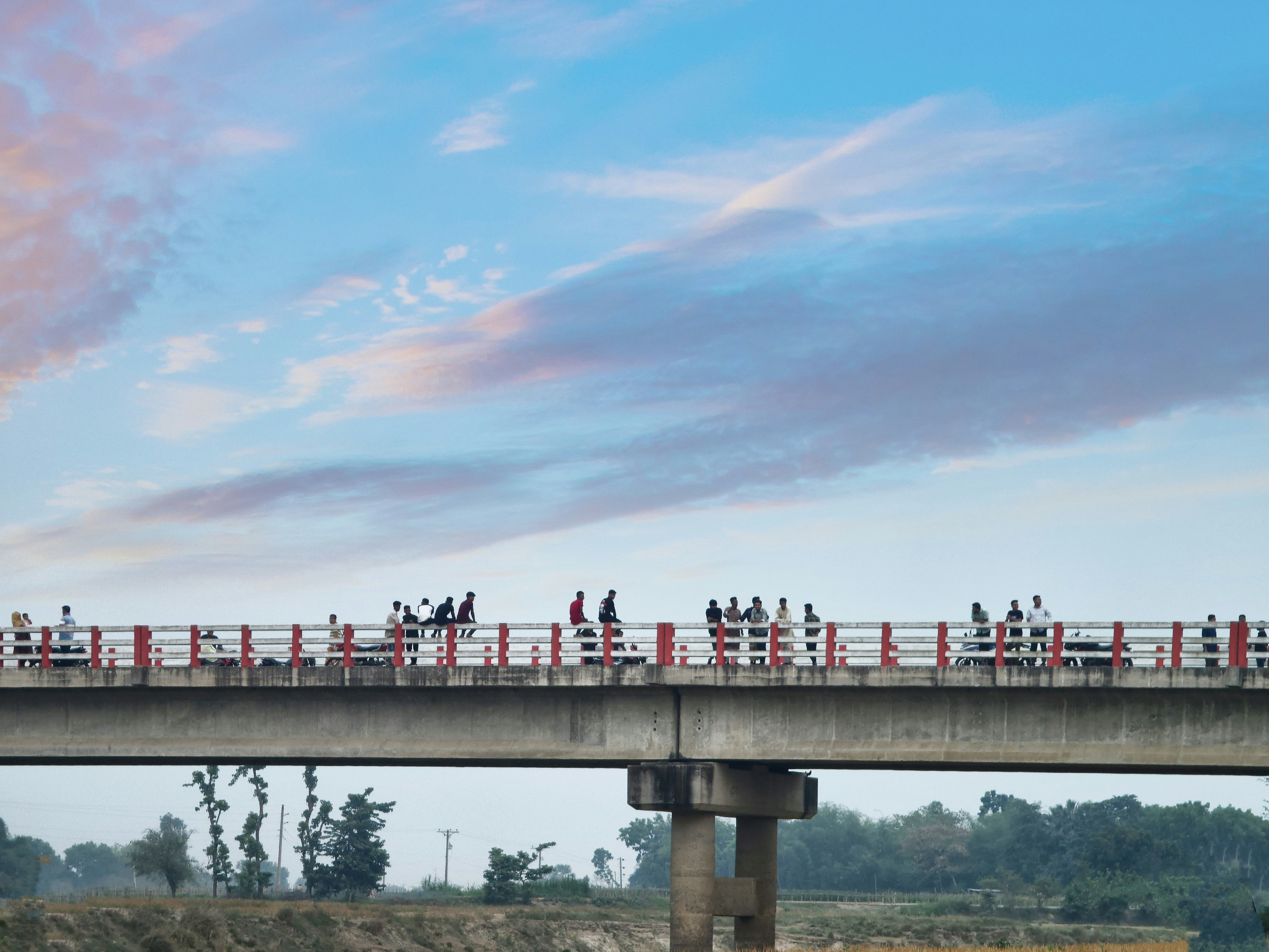 a group of people standing on top of a bridge
