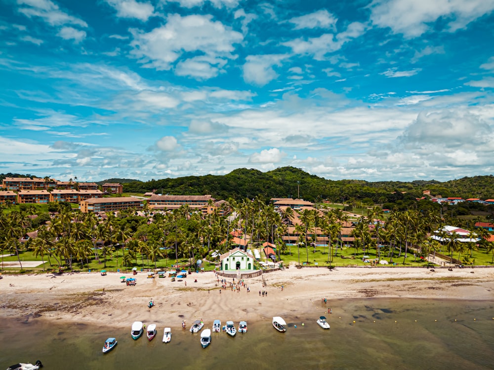 an aerial view of a beach with boats in the water