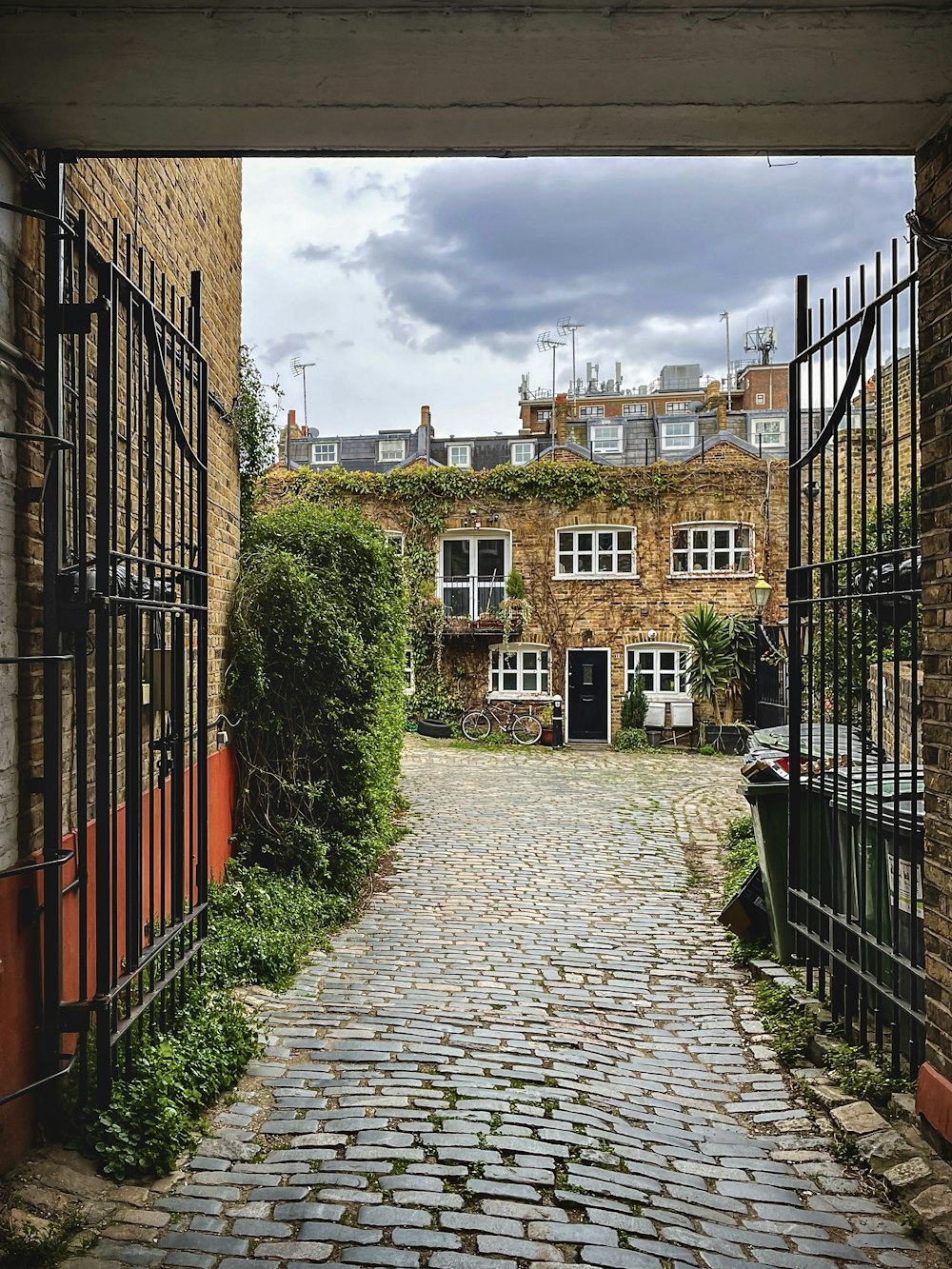 a cobblestone street leading to a brick building