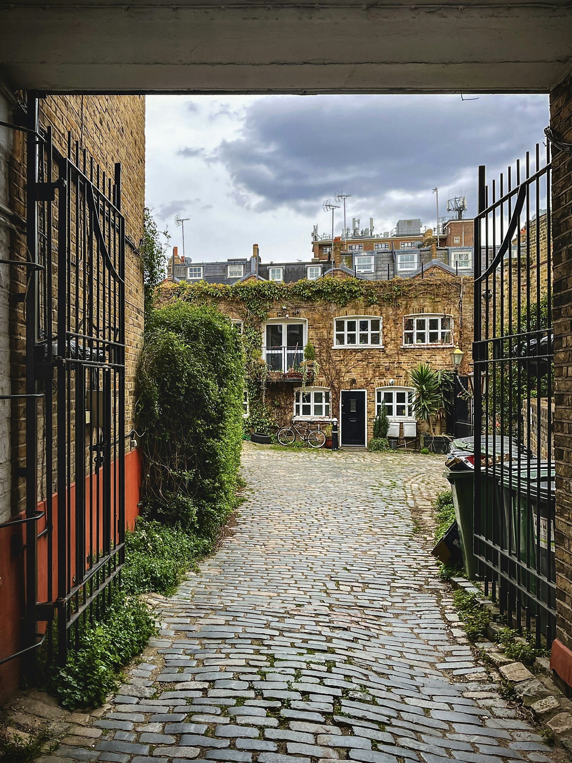 a cobblestone street leading to a brick building