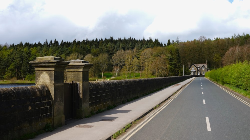 a road with a bridge over it and trees in the background