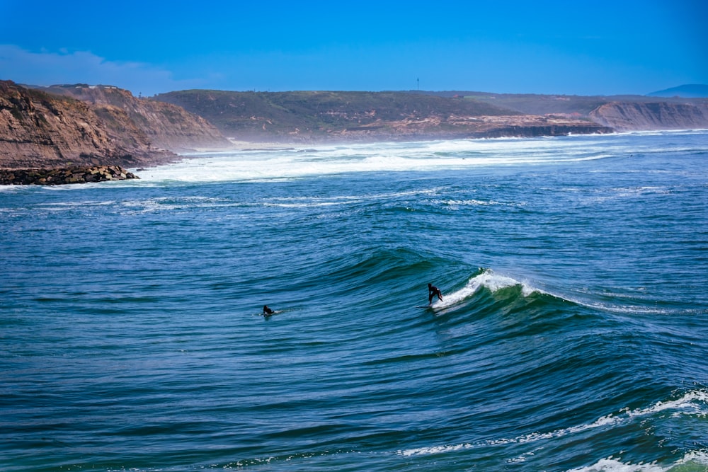 a man riding a wave on top of a surfboard