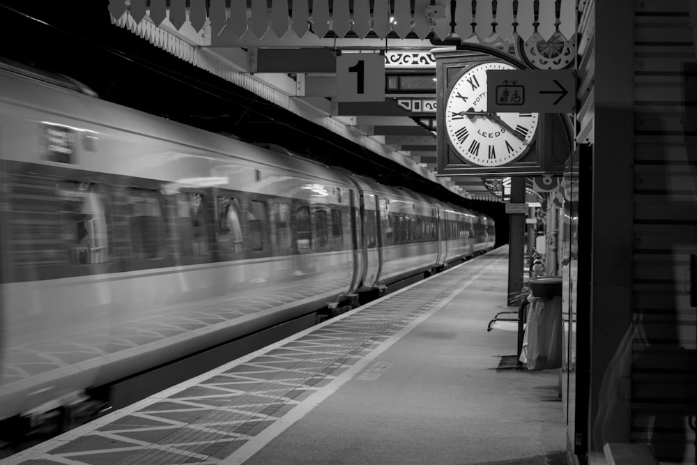 a black and white photo of a train pulling into a station