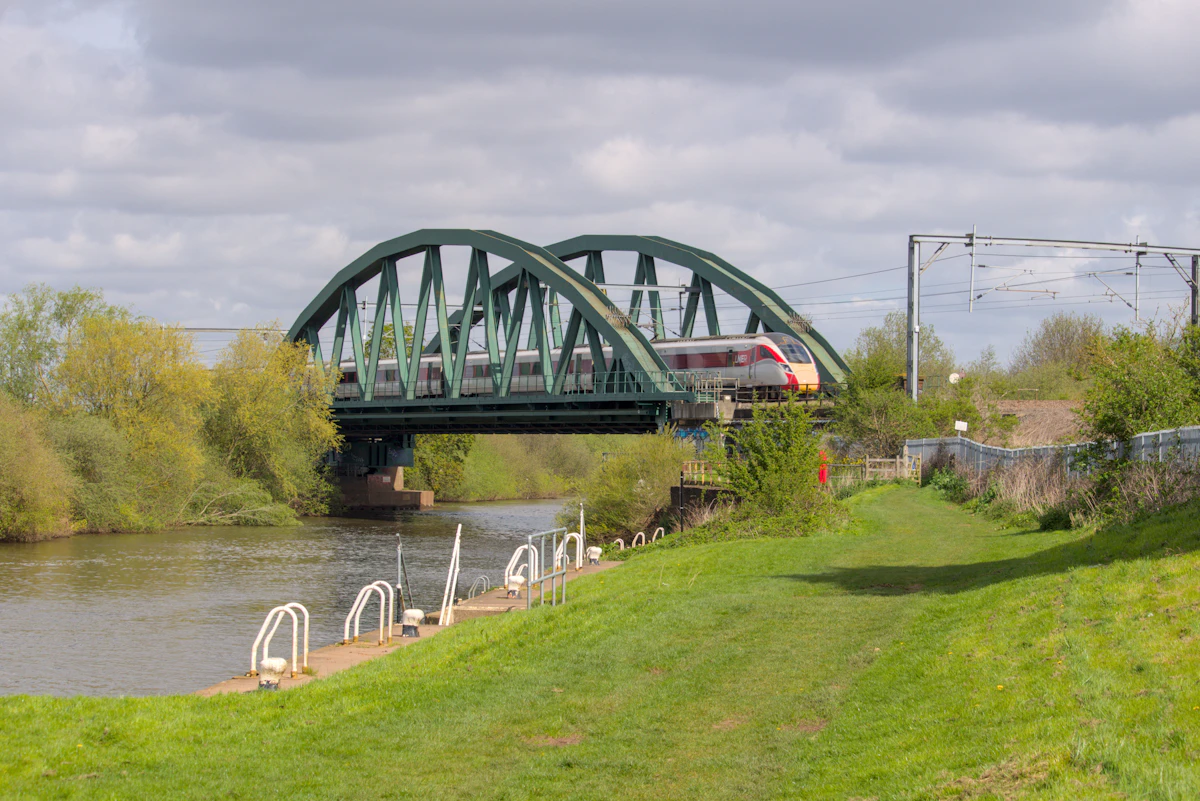 A railway bridge crossing a river under a wide open sky