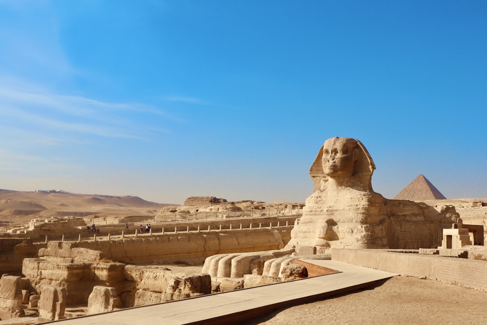 Uma grande estátua da esfinge no meio de um deserto