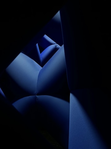 a dark room with a blue couch in it