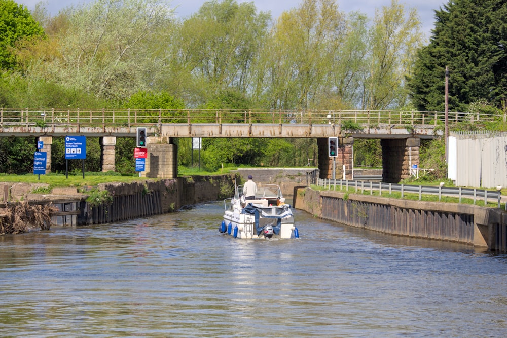 a boat traveling down a river under a bridge