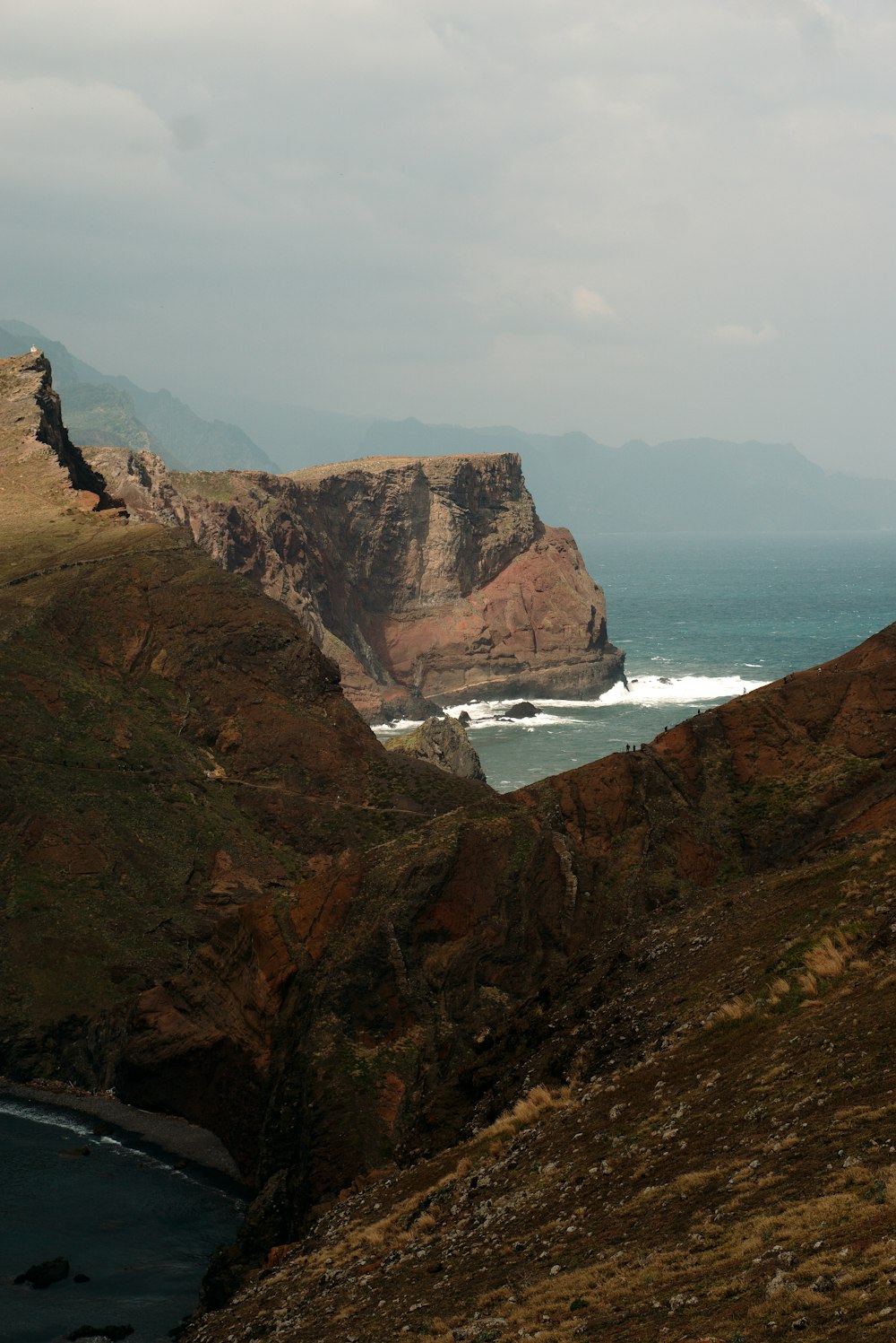 a rocky cliff overlooks a body of water