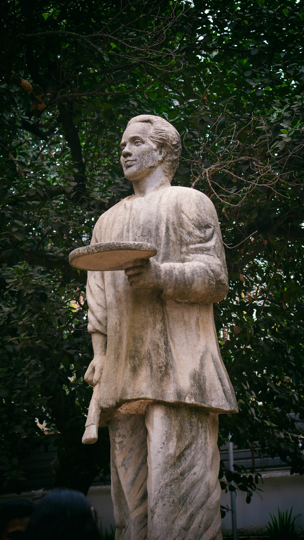 a statue of a man holding a tray of food