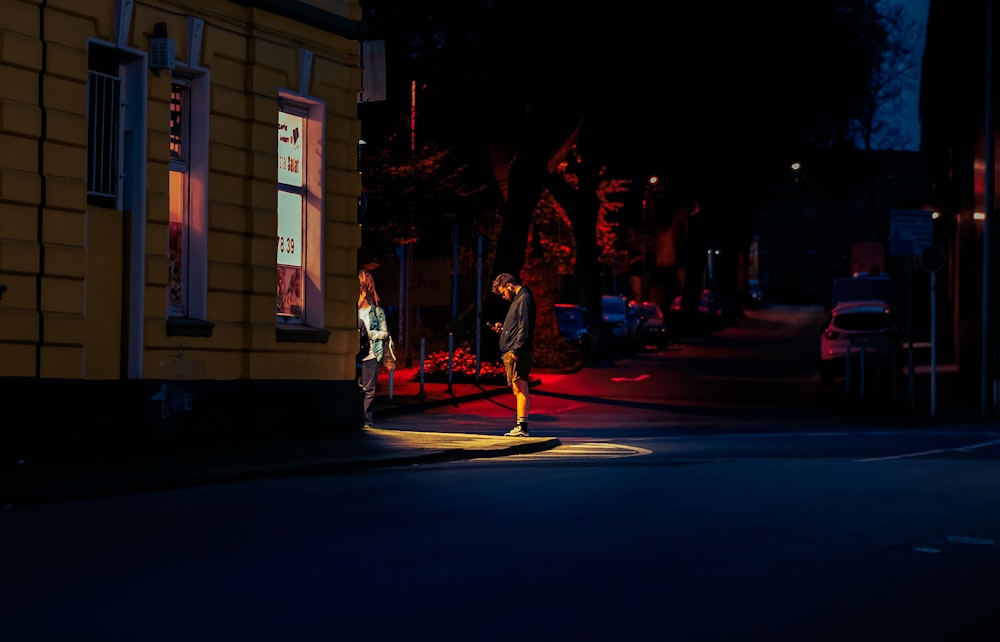 un hombre y una mujer caminando por una calle de noche