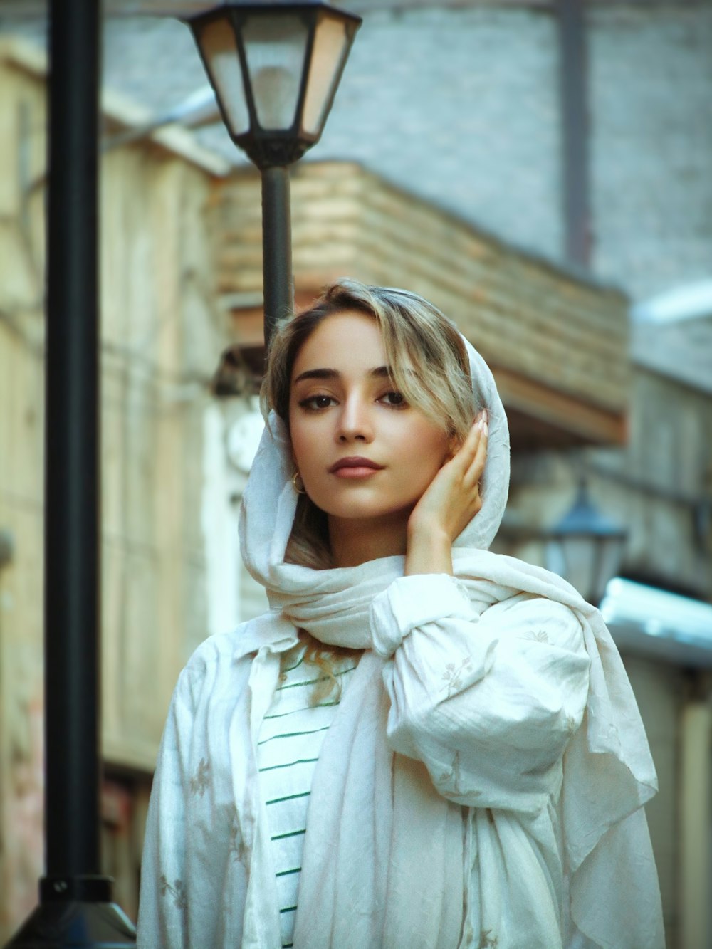 a woman in a white coat and a light pole