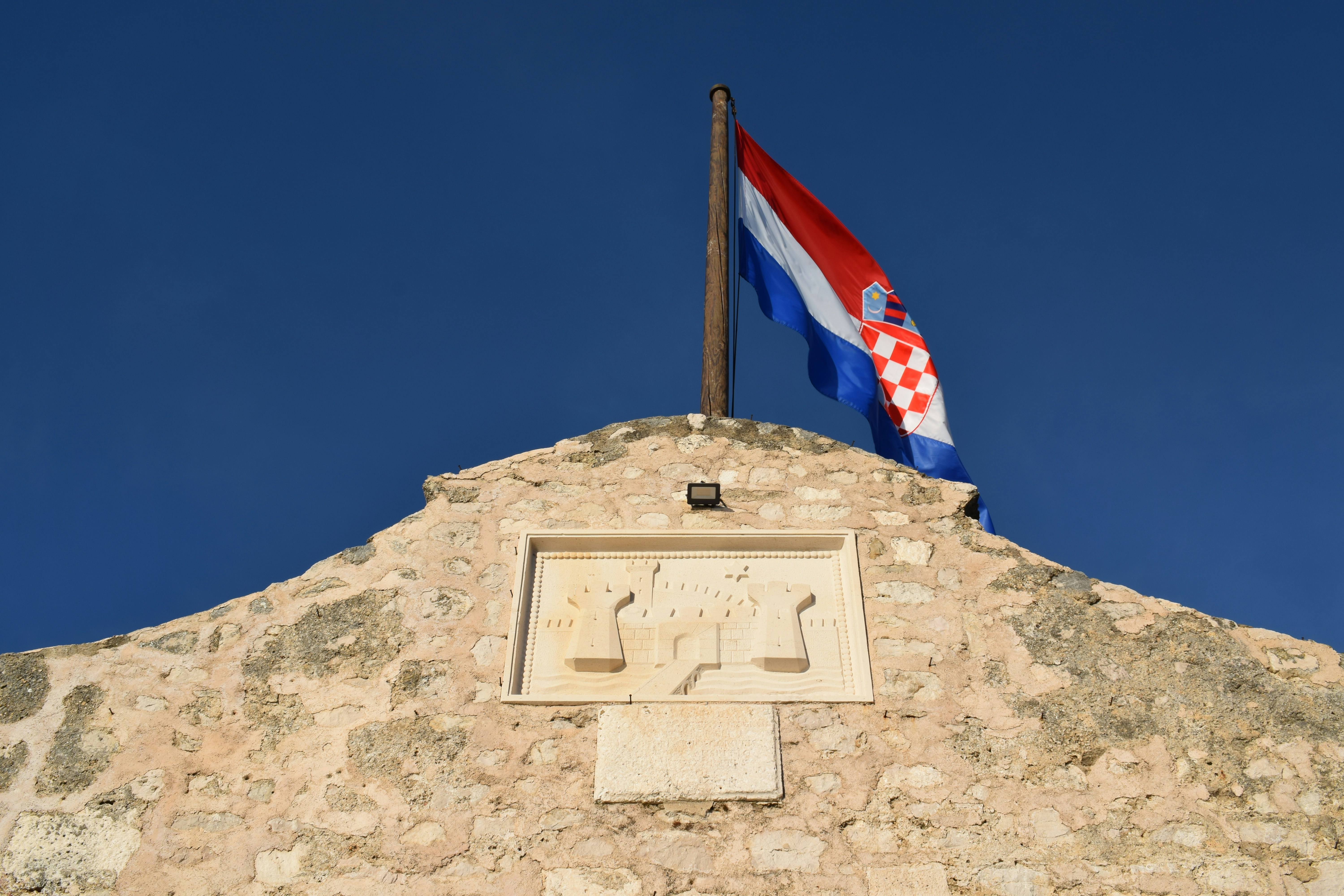 a flag flying on top of a stone building