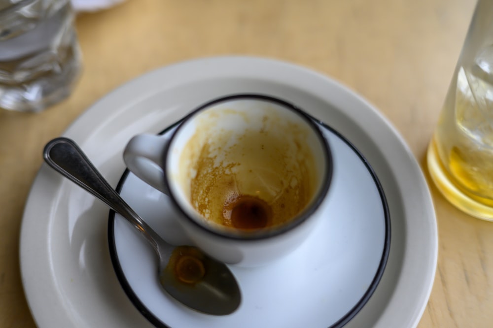 a white plate topped with a cup filled with liquid