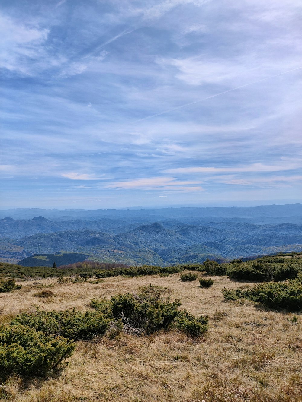 a bench on a hill overlooking a valley and mountains