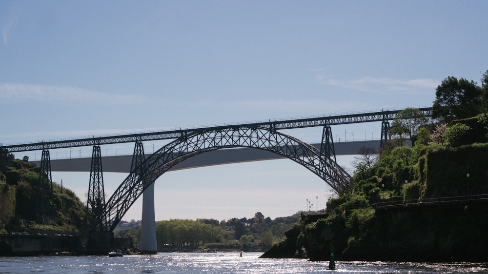 a bridge over a river with a boat in the water