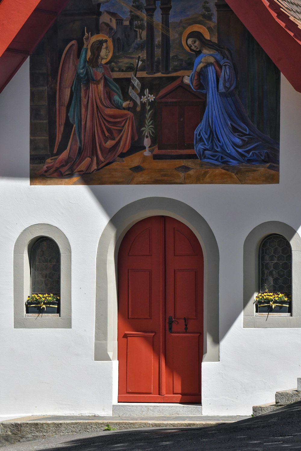 a painting on the side of a building with a red door