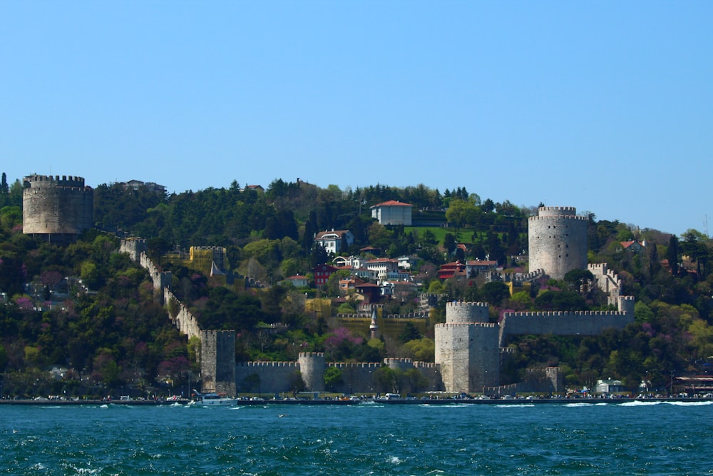 a castle on top of a hill next to a body of water