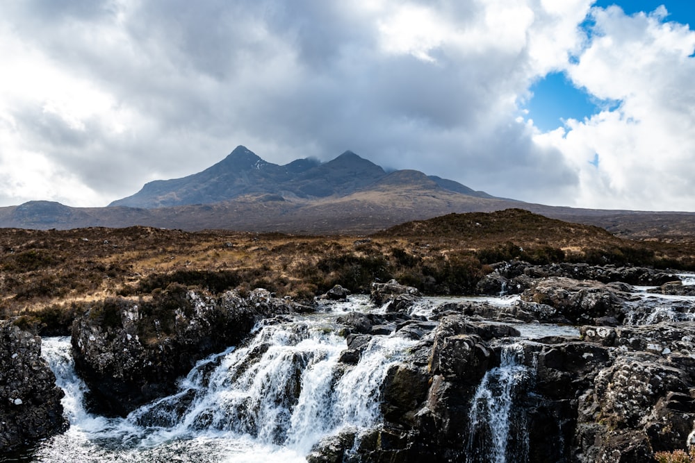 a waterfall with a mountain in the background